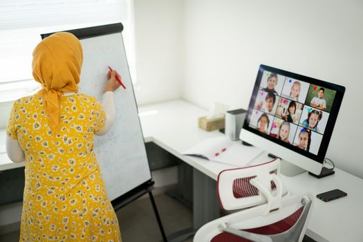 Arabic female teacher working with children online school during pandemic
