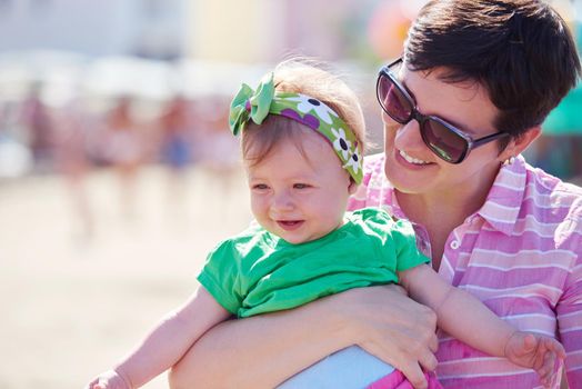 happy mom and baby on beach  have fun while learning to walk and  make first steps