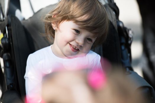 little and very beautiful baby girl sitting in the pram and waiting for mom