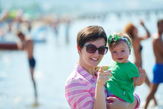 happy mom and baby on beach  have fun while learning to walk and  make first steps