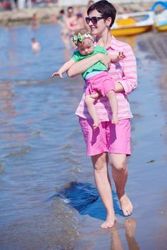 happy mom and baby on beach  have fun while learning to walk and  make first steps