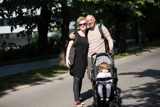 love, parenthood, family, season and people concept  Portrait of a young smiling couple with baby pram in summer park