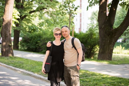 Portrait of a young beautiful happy couple on a sunny day in city park