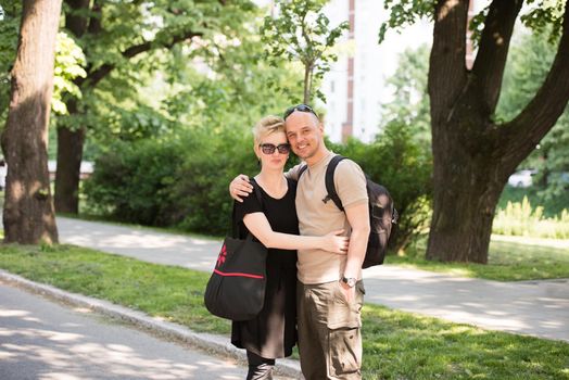 Portrait of a young beautiful happy couple on a sunny day in city park