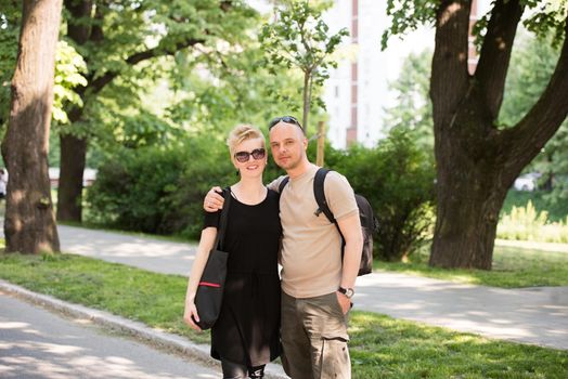 Portrait of a young beautiful happy couple on a sunny day in city park