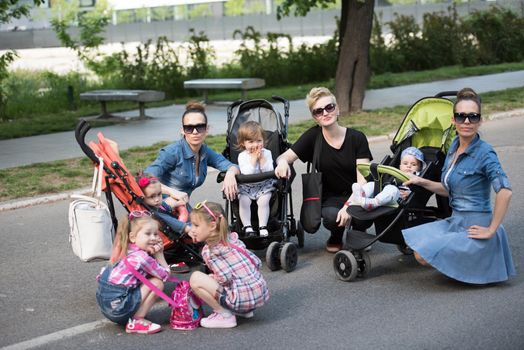 portrait of a group of young beautiful mother with children on a sunny day in the park