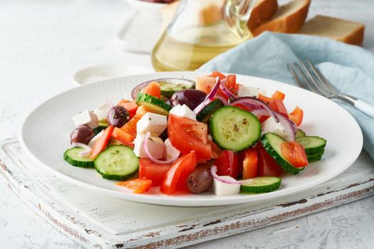 Greek village salad horiatiki with feta cheese, olives, cherry tomato, cucumber and red onion, vegeterian mediterranean food, low calories dieting meal, side view