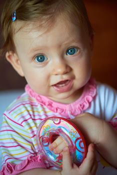 happy baby with first teeth smilling and play with toys