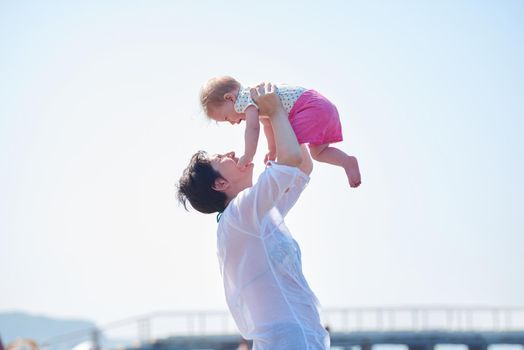 happy mom and baby on beach  have fun while learning to walk and  make first steps