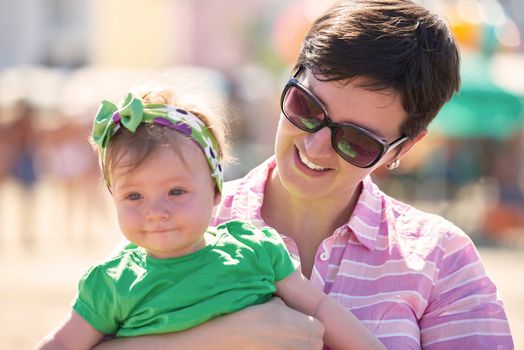 happy mom and baby on beach  have fun while learning to walk and  make first steps