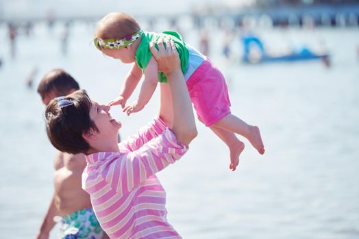 happy mom and baby on beach  have fun while learning to walk and  make first steps