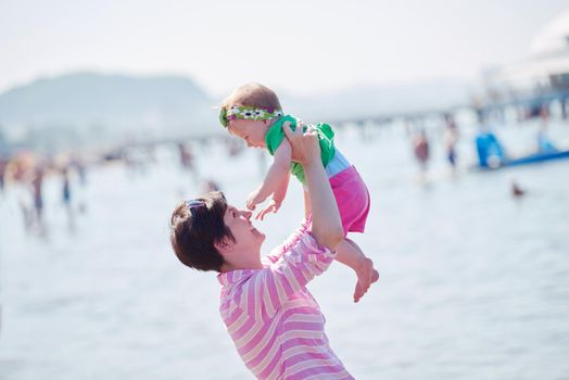 happy mom and baby on beach  have fun while learning to walk and  make first steps