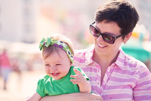 happy mom and baby on beach  have fun while learning to walk and  make first steps