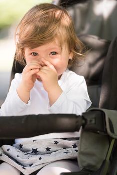 little and very beautiful baby girl sitting in the pram and waiting for mom