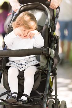 little and very beautiful baby girl sitting in the pram and waiting for mom