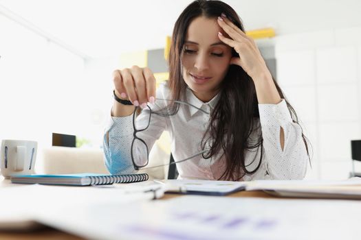 Portrait of tired overworked woman suffer with headache on workplace in office. Stressful and exhausted clerk in office. Hardworker, businesswoman concept