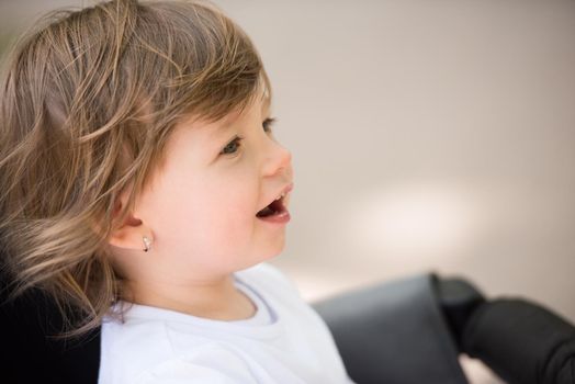 little and very beautiful baby girl sitting in the pram and waiting for mom