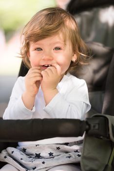 little and very beautiful baby girl sitting in the pram and waiting for mom