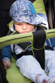 little and very beautiful baby boy sitting in the pram and waiting for mom