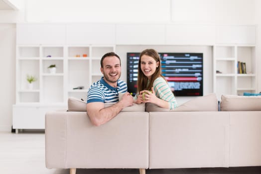 young beautiful handsome couple enjoying morning coffee at home