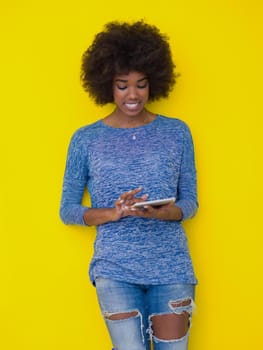 Young Happy African American Woman Using Digital Tablet  Isolated on a yellow background