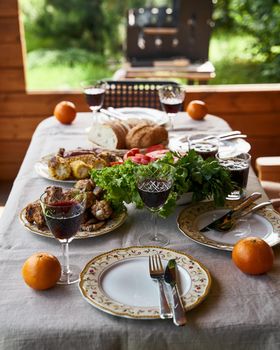 Festive table full of food and glasses full of drink barbecue on background concept of countryside celebration