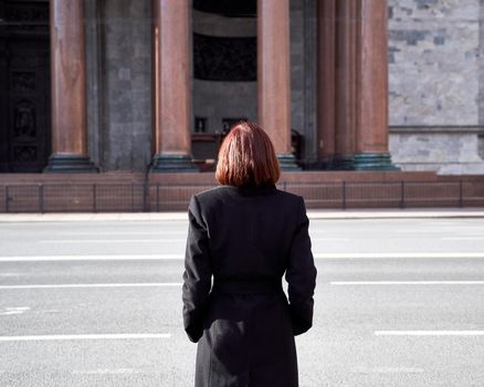 A sad woman with mask on her face stands near closed Museum. Ban on walking and visiting public places due to coronavirus pandemic