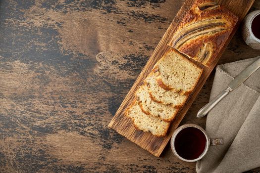 Banana bread. Cake with banana, traditional american cuisine. Slices of loaf. Dark background, black table. Copy space