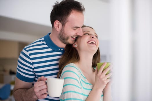 young beautiful handsome couple enjoying morning coffee at home