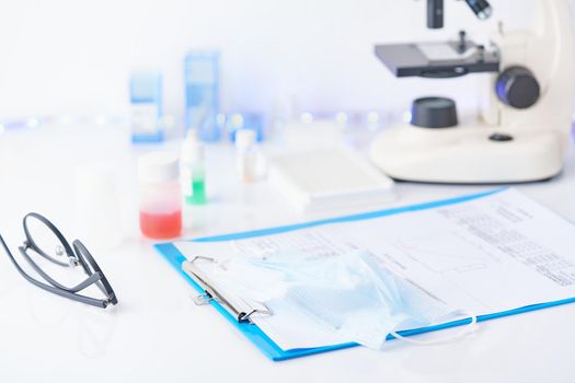 Pandemic COVID-19, Coronavirus. Nobody. Medical supplies, tests, bottles, microscope, clipboard with notes on table. No one is there. Concept of laboratory , development of new drugs and vaccines