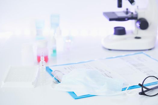 Pandemic COVID-19, Coronavirus. Nobody. Medical supplies, tests, bottles, microscope, clipboard with notes on table. No one is there. Concept of laboratory , development of new drugs and vaccines