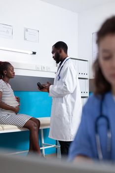 Woman with pregnancy receiving bottle of pills to treat sickness from medic at checkup visit. Pregnant patient expecting child, talking to practitioner about prescription treatment.