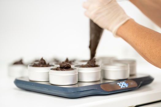 filling molds with hand-made natural organic cosmetics.