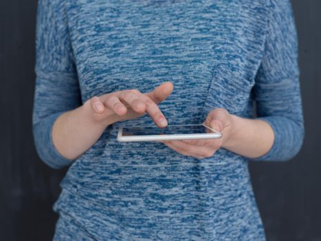 Happy young woman using tablet computer isolated over gray background
