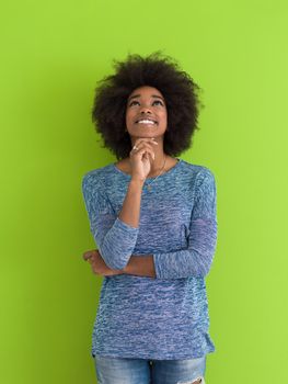 portrait of a beautiful friendly African American woman with a curly afro hairstyle and lovely smile isolated on a Green background