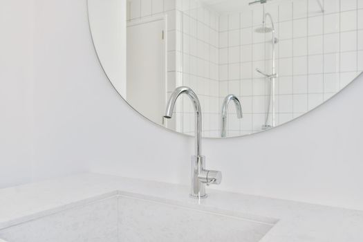 Delightful sink with faucet in front of round mirror