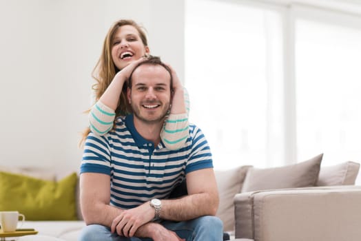 young handsome couple enjoys hugging on the sofa in their luxury home villa