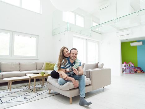 young handsome couple enjoys hugging on the sofa in their luxury home villa