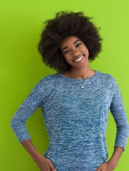 portrait of a beautiful friendly African American woman with a curly afro hairstyle and lovely smile isolated on a Green background