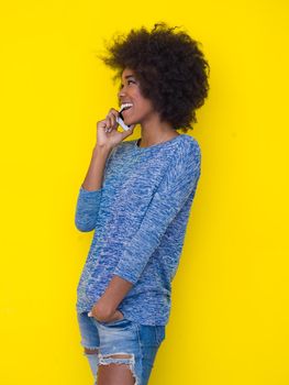 Young Happy African American Woman Using mobile phone  Isolated on a yellow background