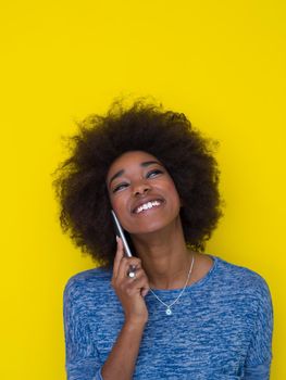 Young Happy African American Woman Using mobile phone  Isolated on a yellow background