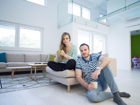 young beautiful handsome couple enjoying morning coffee at home