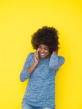 Young Happy African American Woman Using mobile phone  Isolated on a yellow background