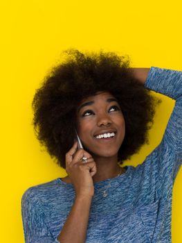 Young Happy African American Woman Using mobile phone  Isolated on a yellow background