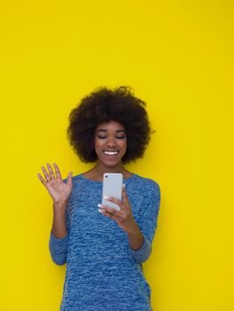 Young Happy African American Woman Using mobile phone  Isolated on a yellow background
