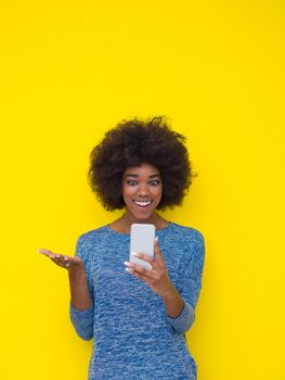Young Happy African American Woman Using mobile phone  Isolated on a yellow background