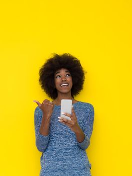 Young Happy African American Woman Using mobile phone  Isolated on a yellow background