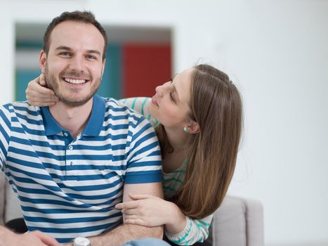 young handsome couple enjoys hugging on the sofa in their luxury home villa