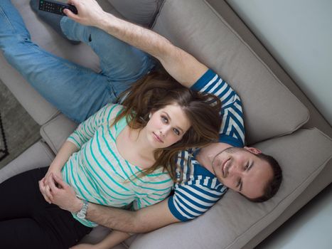 young handsome couple enjoys hugging on the sofa in their luxury home villa