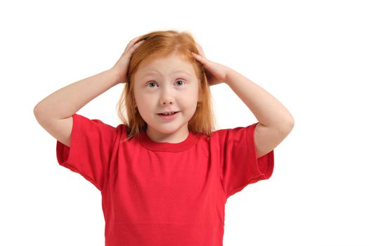 Portrait of cute redhead emotional little girl in red t-shirt isolated on a white. Beautiful studio portrait of female little caucasian person holding her head stressed
